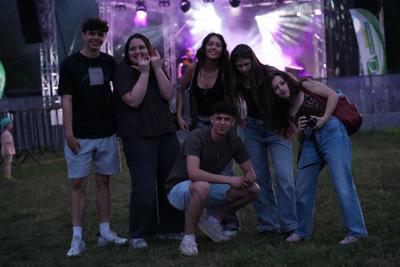 Grupa osób zebrana niedaleko sceny pozuje do zdjęcia.