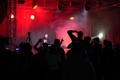 Grupa osób pod sceną bawiąca się.