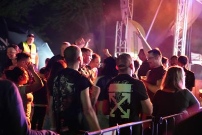Grupa osób pod sceną bawiąca się.