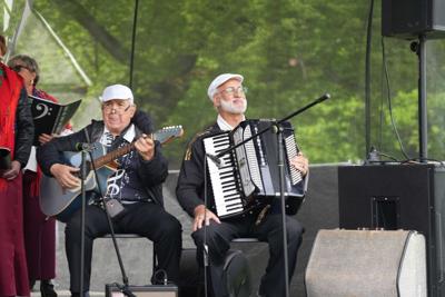 Artyści grają na gitarze i akordeonie.