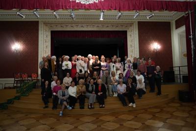 Grupa osób pozująca na schodach na scenę.