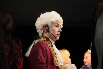 Pan w historycznym przebraniu z mikrofonem.