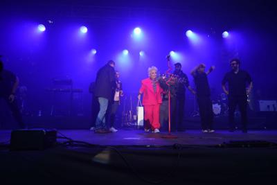 Grupa osób na scenie. Pani otrzymała bukiet oraz upominek.