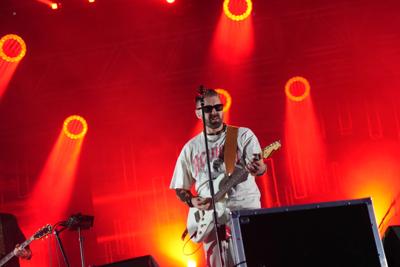 Mężczyzna z gitarą śpiewa na scenie.