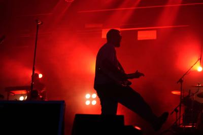 Mężczyzna gra na gitarze na scenie.