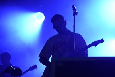 Mężczyzna gra na gitarze na scenie.