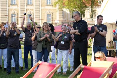 Grupa osób. W tle budynek.