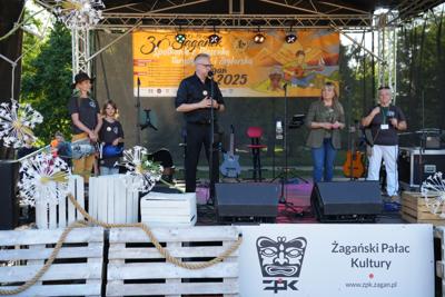 Grupa osób na scenie - pan przemawia.