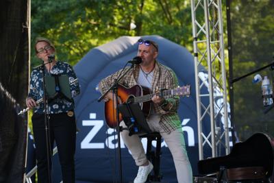 Występ muzyczny na scenie - pani gra na flecie poprzecznym, pan na gitarze.