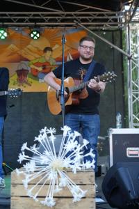 Pan z gitarą na scenie.