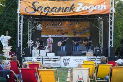 Występ grupy muzycznej na scenie. Publiczność ogląda.