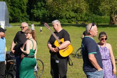 Grupa osób, na środku pan z gitarą.