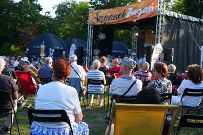 Zebrana na krzesłach wokół sceny publiczność ogląda występy.