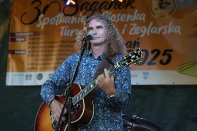Pan występuje z gitarą.
