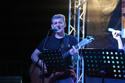 Pan występuje z gitarą na scenie.