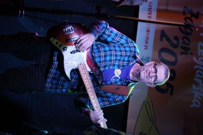 Pan występuje z gitarą na scenie.