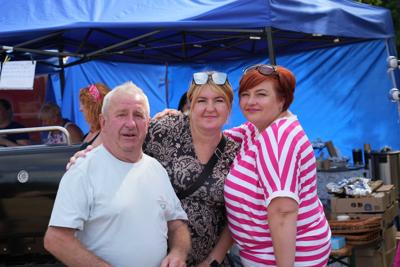 Trzy osoby obejmują się pozując do zdjęcia.