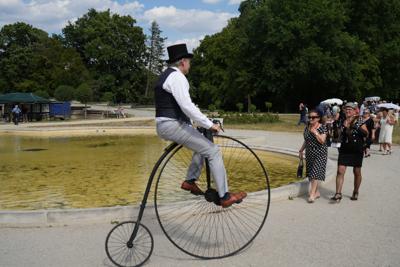 Pan jedzie na bicyklu wzdłuż fontanny.