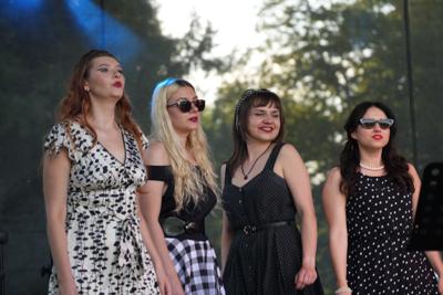 Grupa artystów na scenie.