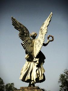 Posąg anioła trzymającego w dłoni wieniec, od tyłu.