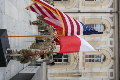 Żołnierze stojący przy flagach Polski i Stanów Zjednoczonych.
