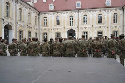 Grupa żołnierzy, przed nimi budynek.