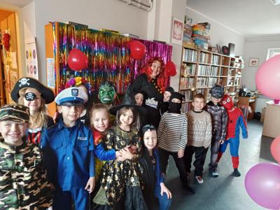 dzieci w kostiumach razem z bibliotekarką