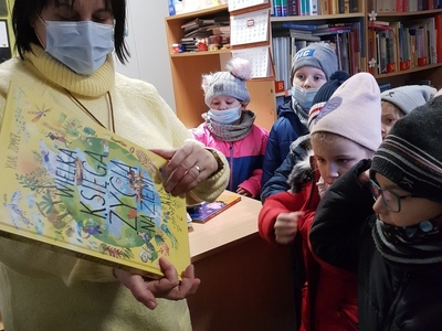 bibliotekarka pokazuje dzieciom książkę