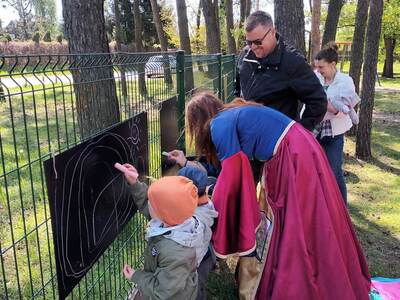 Dzieci rysujące kredą po czarnych planszach.
