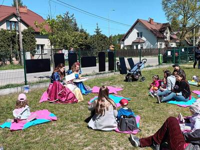 Bibliotekarki czytające dzieciom bajkę.