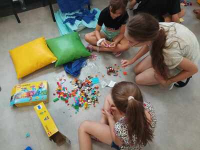 Dzieci budują scenografie z klocków lego.