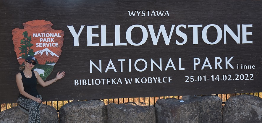 plakat informujący o wystawie z autorką fotografii na tle napisu Yellowstone National Park