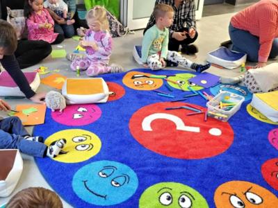 Dzieci bawią się na dywanie.