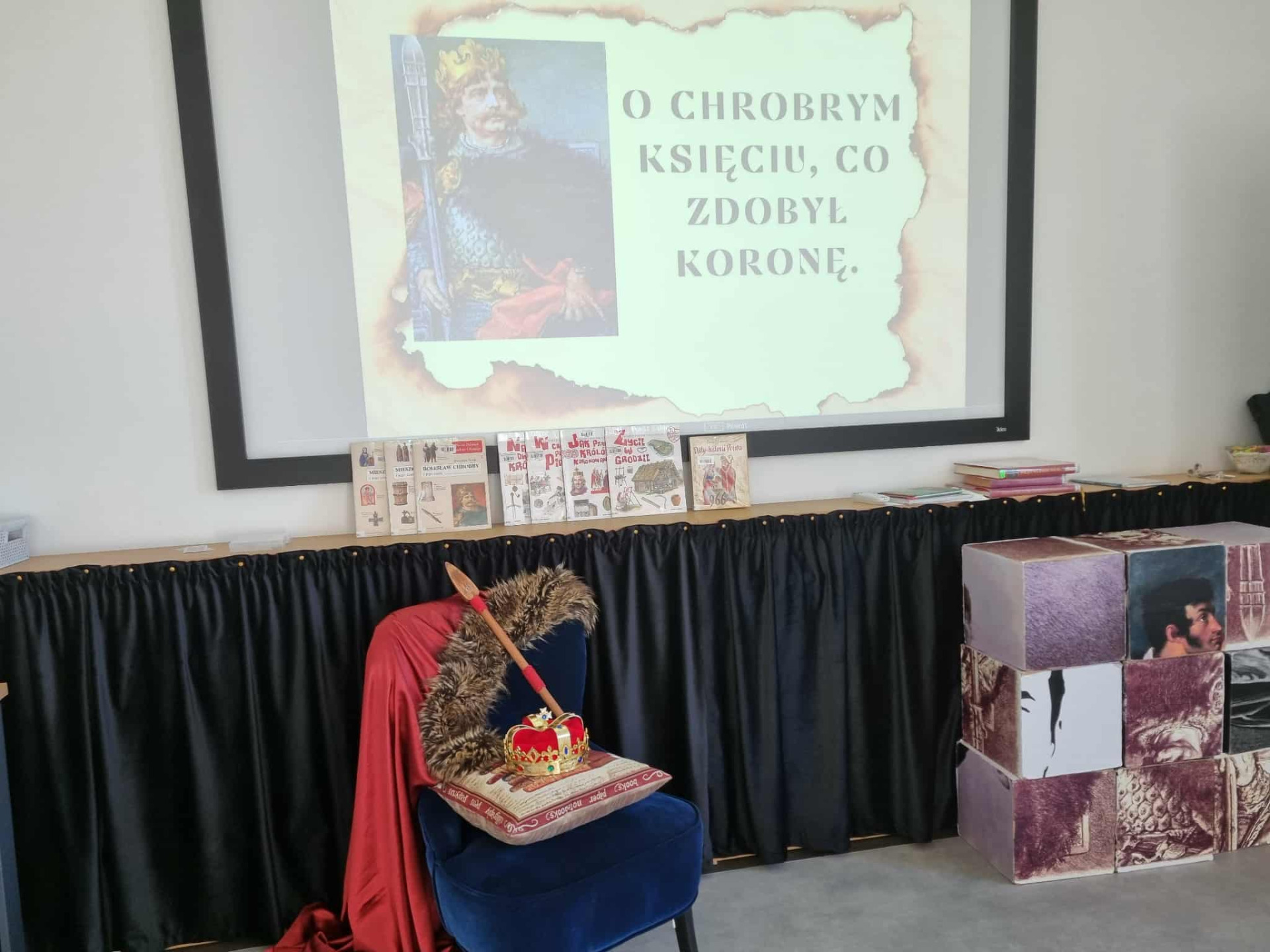 Fotel a na nim, korona, berło i poducha. 