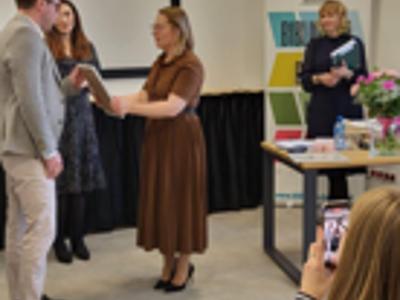 Kobieta wręcza podziękowanie.