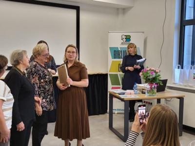 Grupa ludzi stoi i rozmawia.