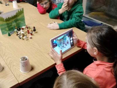 Dzieci wykonują zdjęcia tabletem.