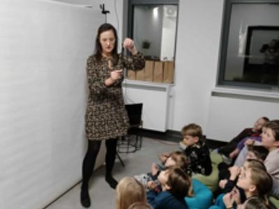 Kobieta pokazuje dzieciom kliszę filmu.