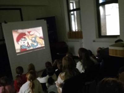 Dzieci ogladają bajkę Smerfy.