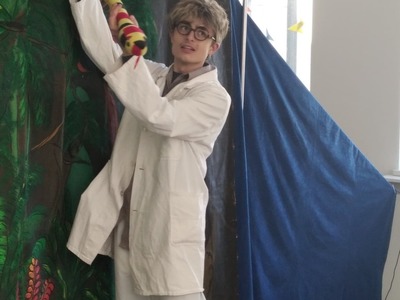 Aktor przebrany za Doktora Dolitlle trzyma pluszowego węża.