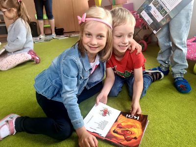 Dzieci przytulające się i oglądające książkę.