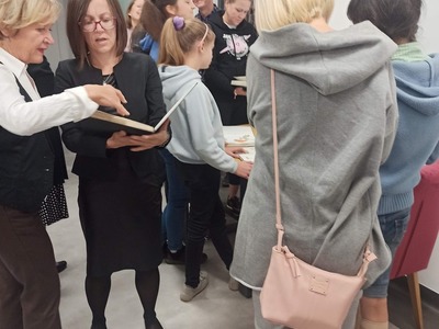 Uczestnicy spotkania oglądają szkicowniki Agnieszki Grzelak
