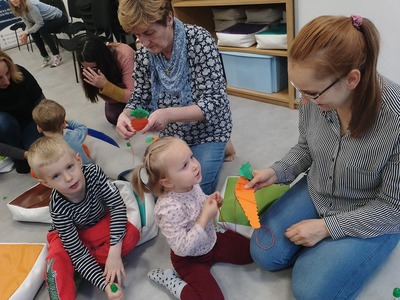 Dzieci z rodzicami wykonują pracę plastyczną.