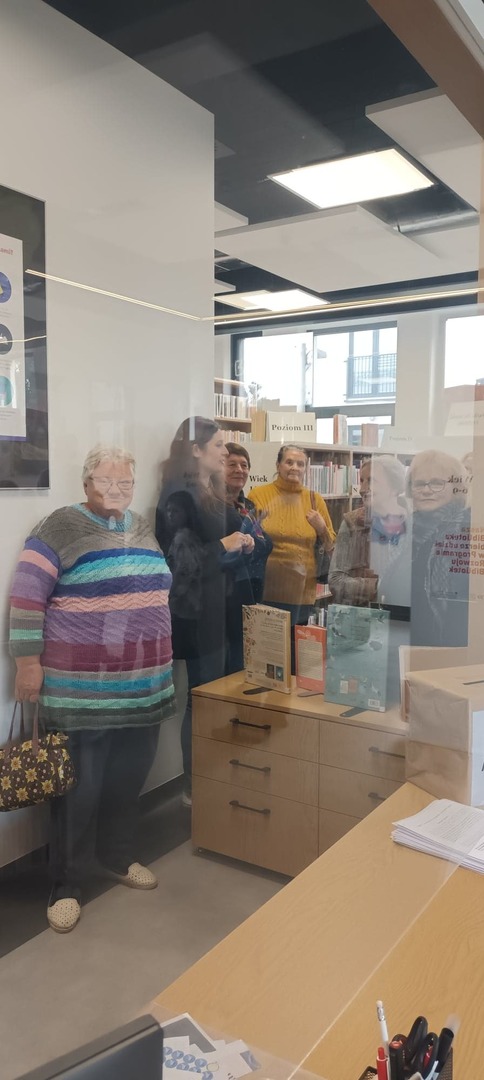 Seniorzy zwiedzają bibliotekę.