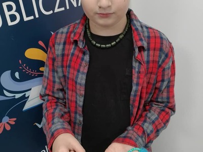 Chłopiec pokazuje jaki breloczek wykonał.