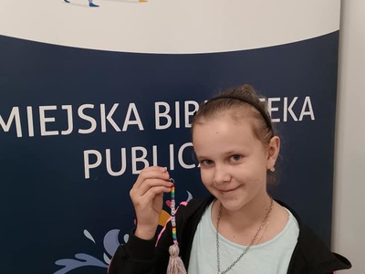 Dziewczynka pokazuje swój breloczek.
