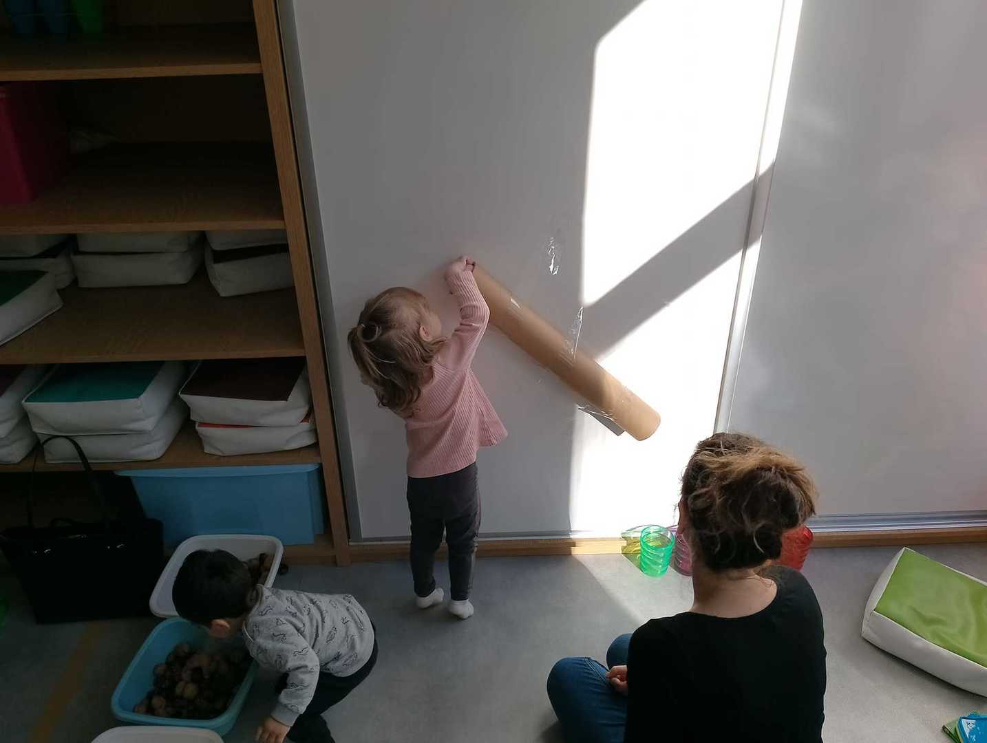 Dziewczynka wrzuca piłkę do rury.