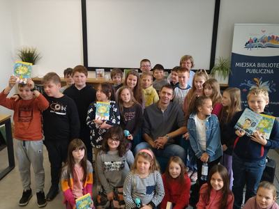 Uczestnicy spotkania na fotografii z gościem - Rafałem Witek