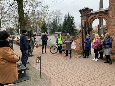 Zdjęcie przedstawiające uczestników wydarzenia stojących pod bramą Starego Cmentarza w Kobyłce.