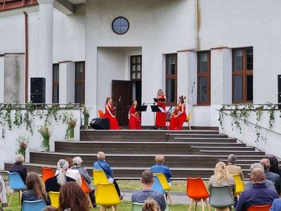 Widok na taras BPiCAK. Na tarasie UpBeat Quartet - od lewej: skrzypce - Joanna Trzaska,  skrzypce - Natalia Zhukava, altówka - Weronika Rácz, wiolonczela - Zuzanna Siepietowska. Na trawniku przed tarasem widownia